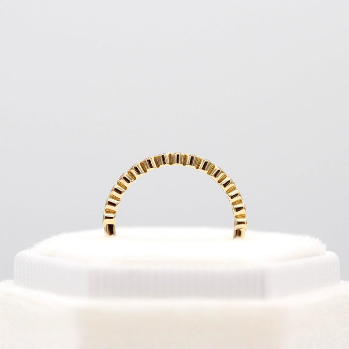 The October Florence Birthstone Wedding Band with Peachy-Pink Sapphire in Yellow Gold in a white velvet ring box