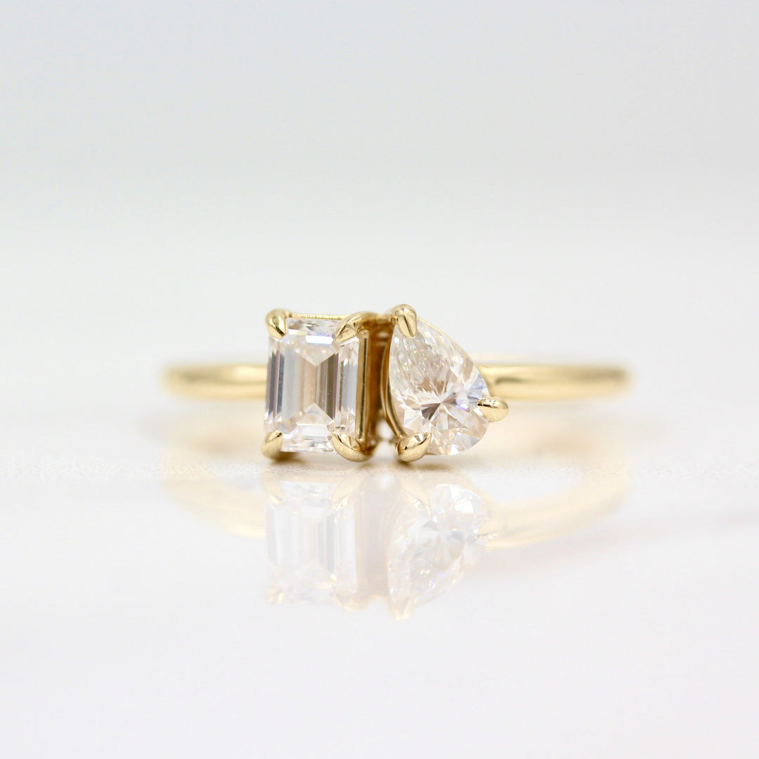 Two stone ring in yellow gold against white background