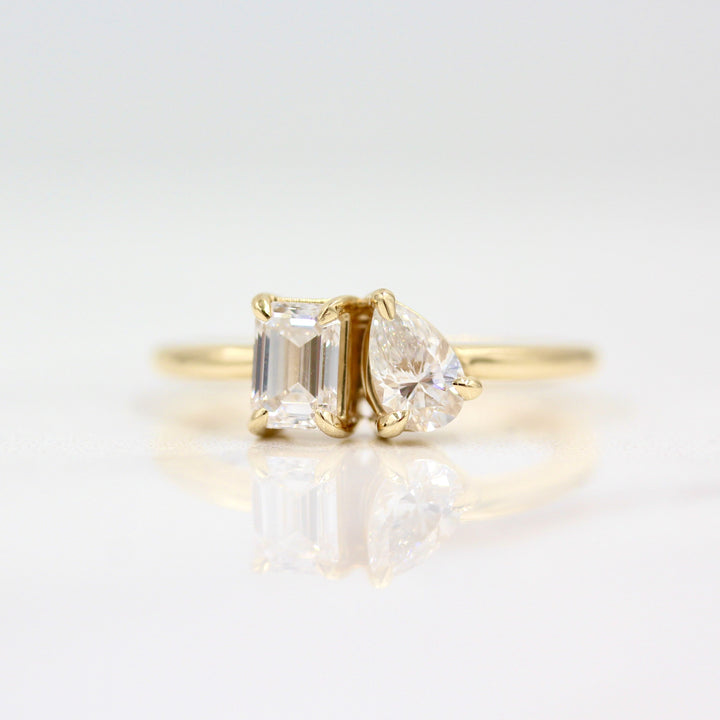 Two stone ring in yellow gold against white background