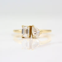 Two stone ring in yellow gold against white background