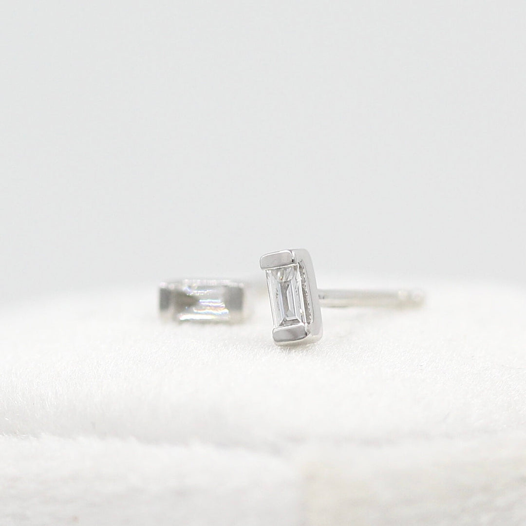 Petite Baguette Earrings in White Gold atop a white velvet ring box