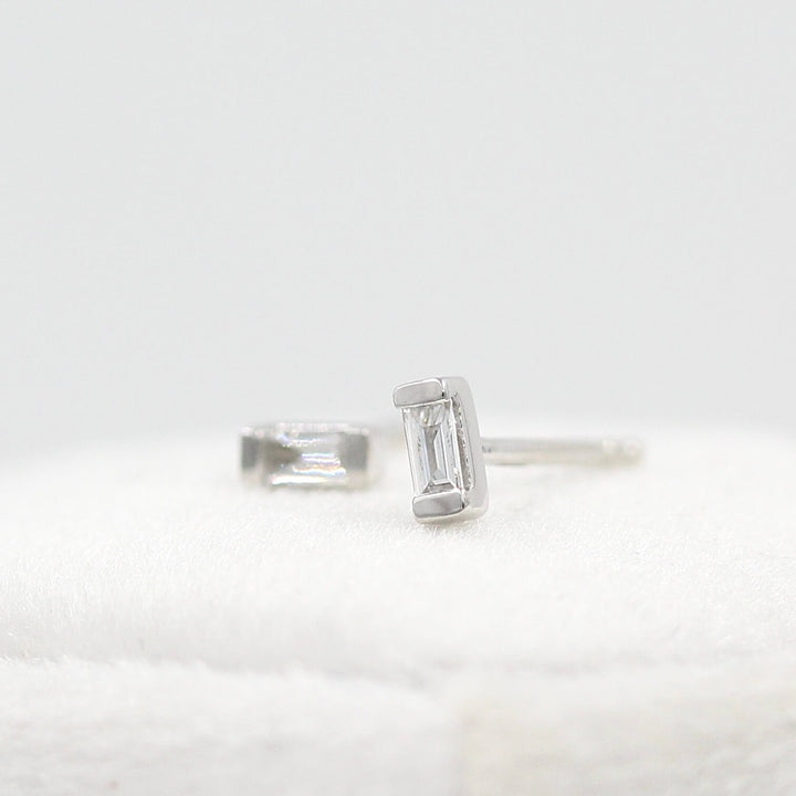 Petite Baguette Earrings in White Gold atop a white velvet ring box