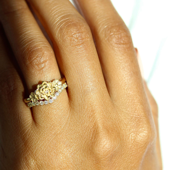 The Posy Ring in Yellow Gold stacked with the Florence Contour wedding band in yellow gold modeled on a hand