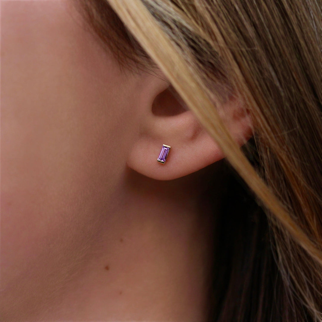 The February Baguette Birthstone Earrings with Purple Sapphire in Yellow Gold modeled