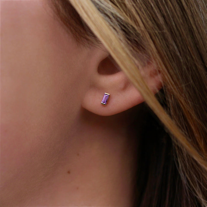 The February Baguette Birthstone Earrings with Purple Sapphire in Yellow Gold modeled