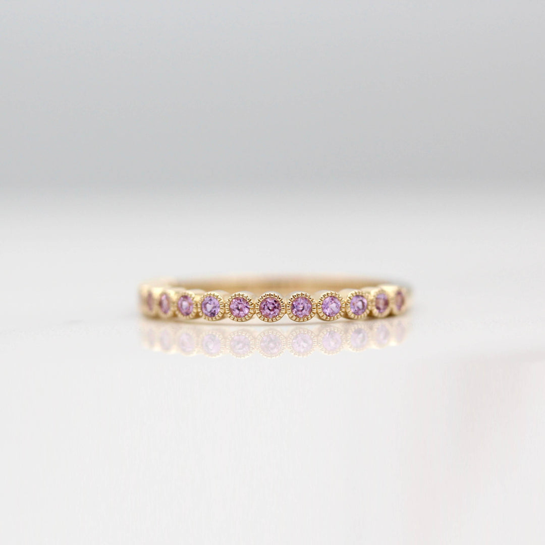 The February Florence Birthstone Wedding Band with Purple Sapphire in Yellow Gold against a white background