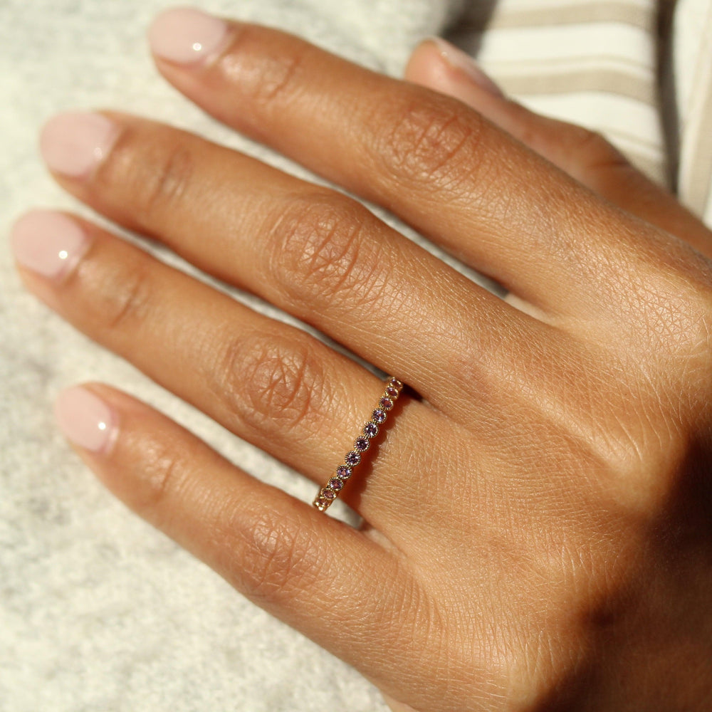 The February Florence Birthstone Wedding Band with Purple Sapphire in Yellow Gold modeled