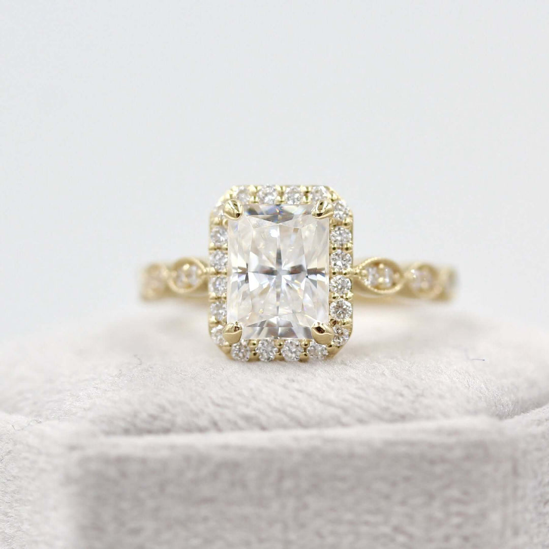 Radiant halo engagement ring on light grey velvet box