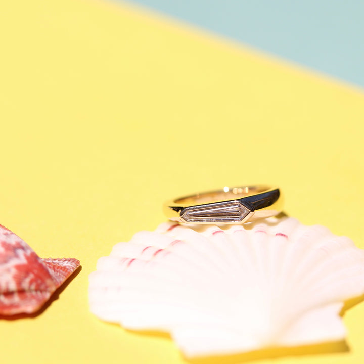 Yellow Gold Pinky ring with Shield Shape Diamond on a White Shell with Yellow Background