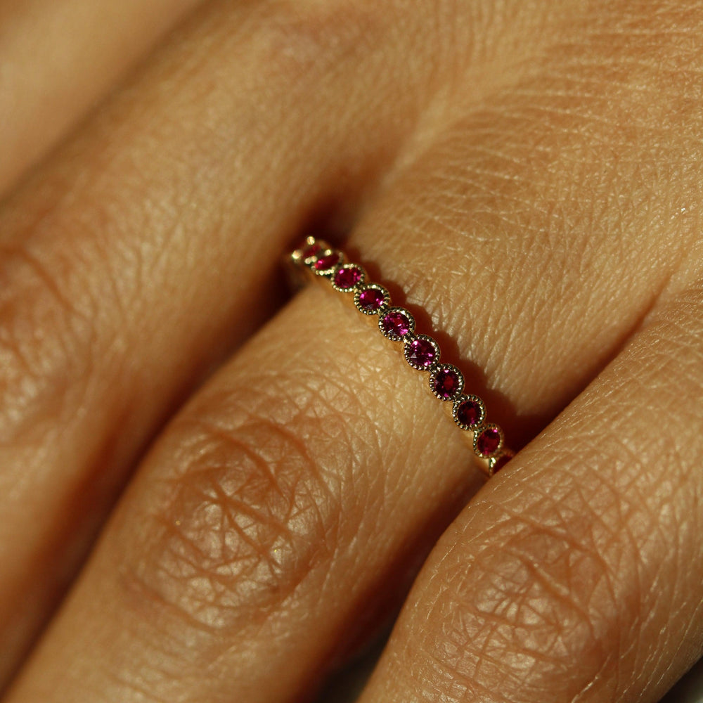 The July Florence Birthstone Wedding Band with Ruby in Yellow Gold modeled