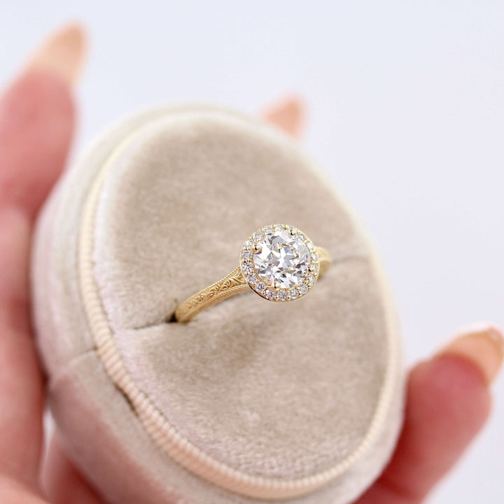 The Sabrina Ring (OEC) in Yellow Gold and 1.37ct Lab-Grown Diamond in a white velvet ring box held by a hand