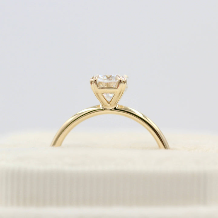 Velvet box showing side view of the Serena elongated cushion solitaire engagement ring in 14k yellow gold