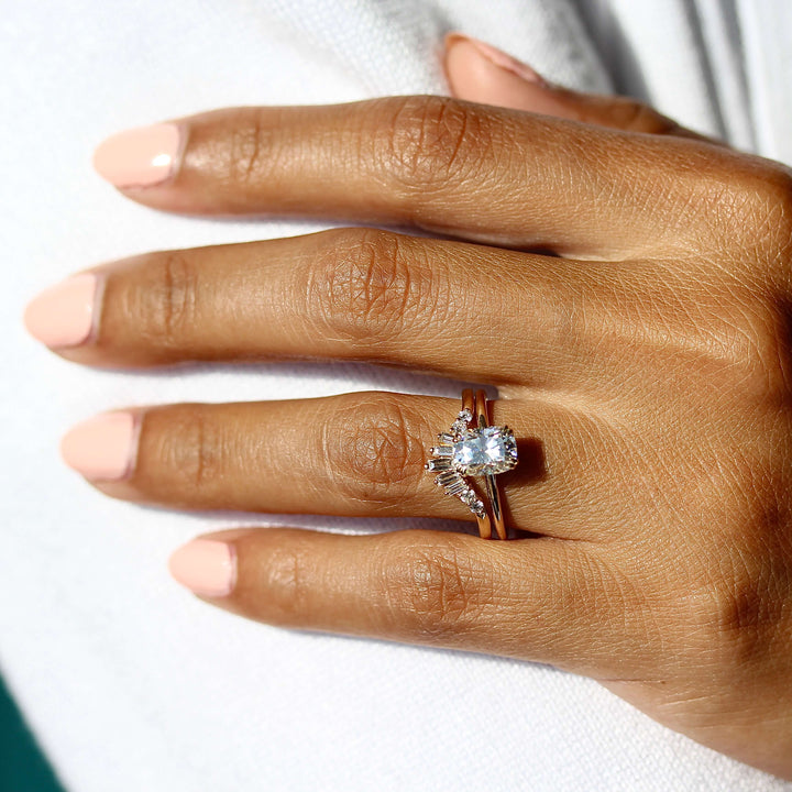 The Serena Ring (Elongated Cushion) in yellow gold stacked with the Sunburst wedding band in yellow gold modeled on a hand