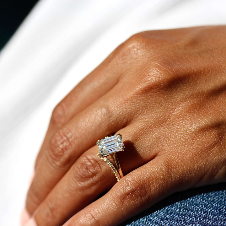 The Serena Ring (Emerald) in Yellow Gold stacked with the Diamond V-Band in yellow gold modeled on a hand