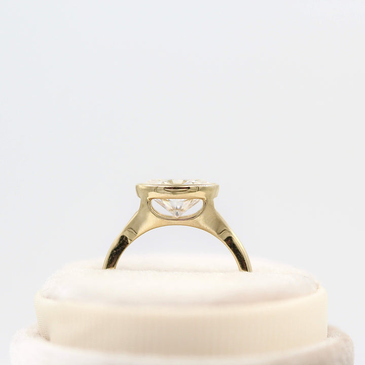 The Stevie Ring (east-west oval) in yellow gold in a white velvet ring box