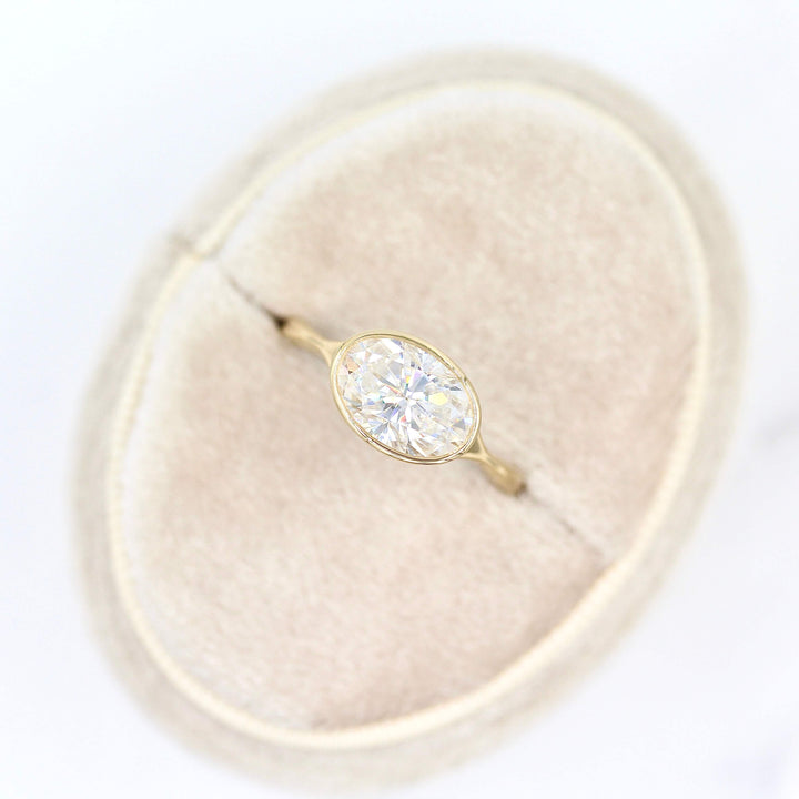 The Stevie Ring (east-west oval) in yellow gold in a white velvet ring box