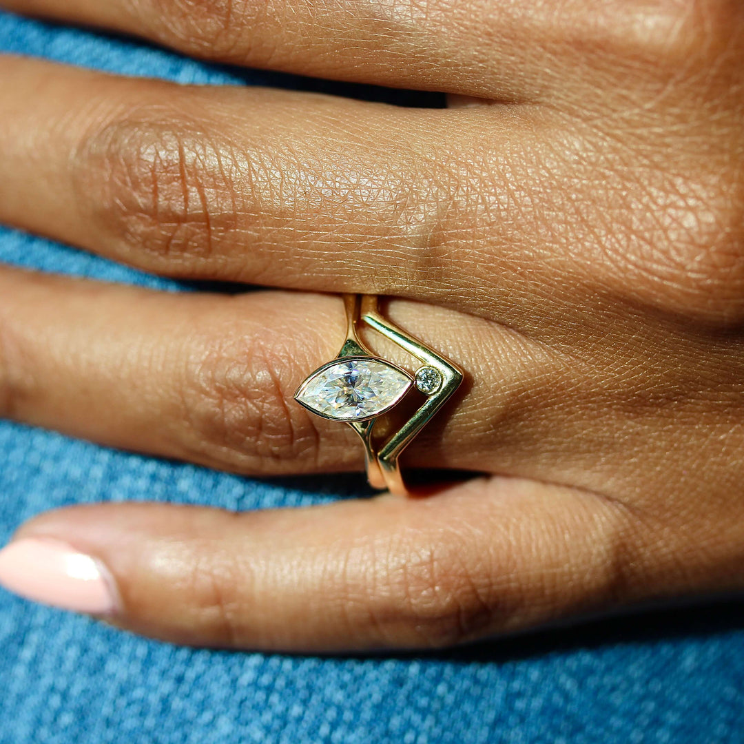 The Stevie Ring (Marquise) in Yellow Gold stacked with the Single Diamond V-Band in yellow gold modeled on a hand