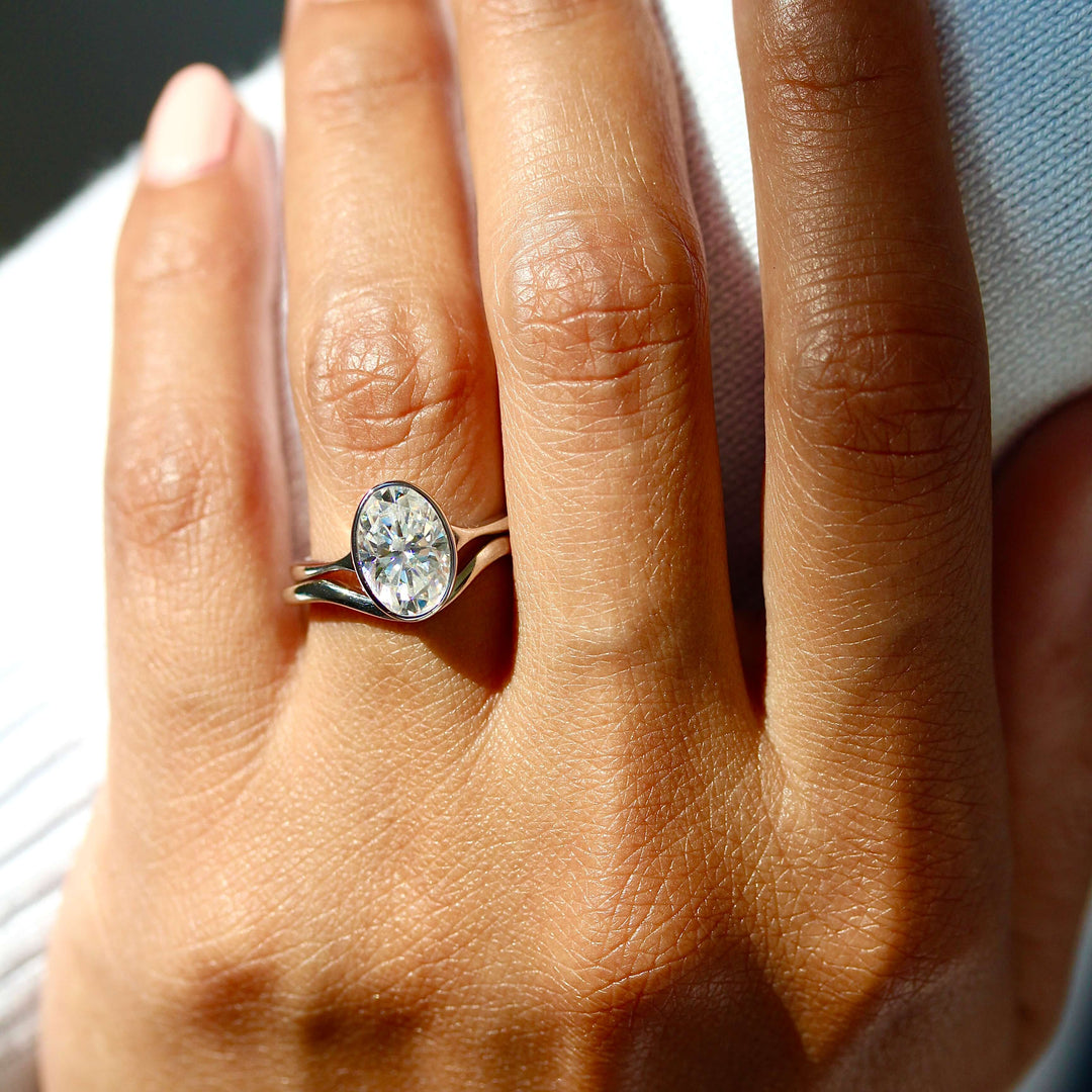 The Stevie Ring (Oval) in White Gold stacked with the Wave wedding band in white gold modeled on a hand