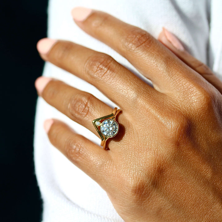 The Stevie Ring (Round) in Yellow Gold stacked with the Diamond V-Band in yellow gold modeled on a hand