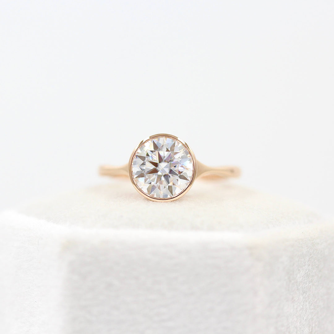 The Stevie Ring (Round) in Rose Gold with 2ct Moissanite atop a white velvet ring box