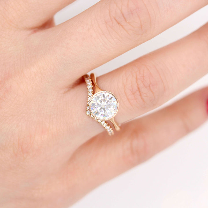 The Stevie Ring (Round) in Rose Gold with 2ct Moissanite stacked with the Diamond V-Band in rose gold modeled on a hand