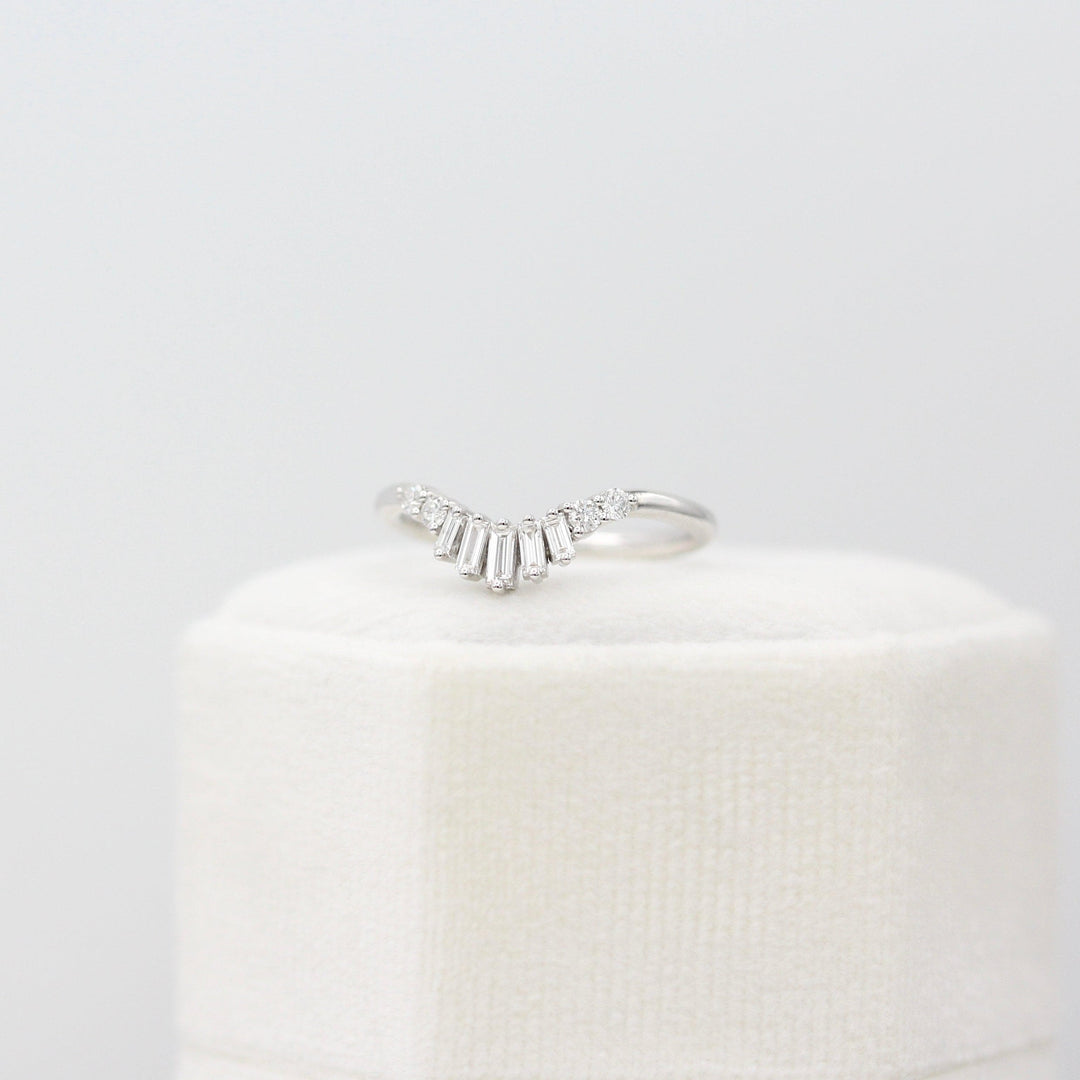 The Sunburst Wedding Band in White Gold atop of a white velvet ring box