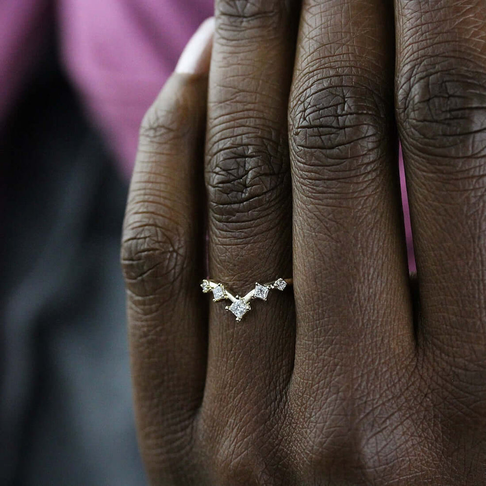 The Astra Wedding Band in Yellow Gold modeled on a hand