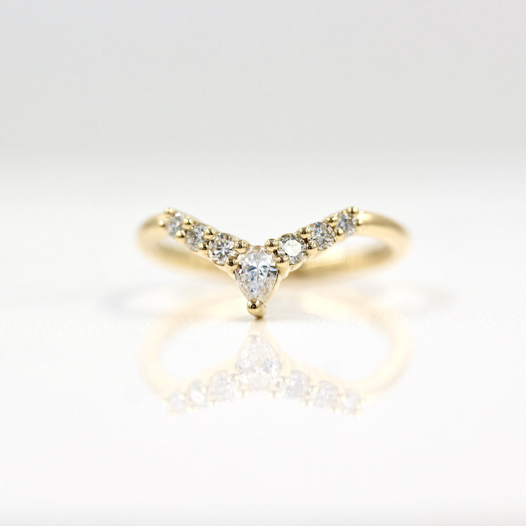 Lab-grown diamond contour wedding band in yellow gold with six rounds and a pear diamond at the top