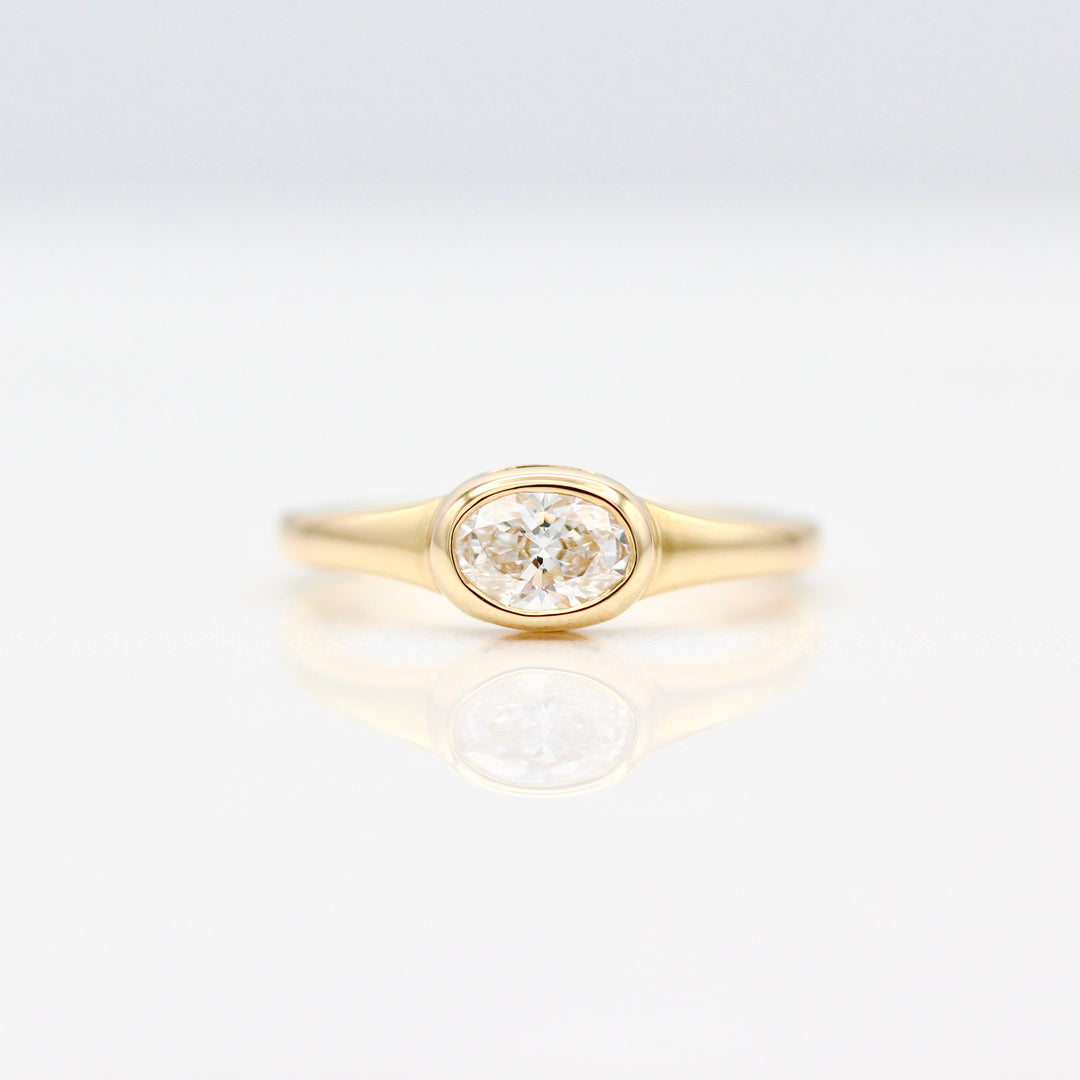 East-West Oval Diamond Pinky Ring in Yellow Gold on a White Background
