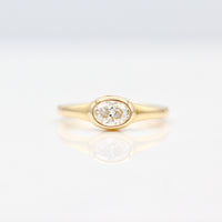 East-West Oval Diamond Pinky Ring in Yellow Gold on a White Background