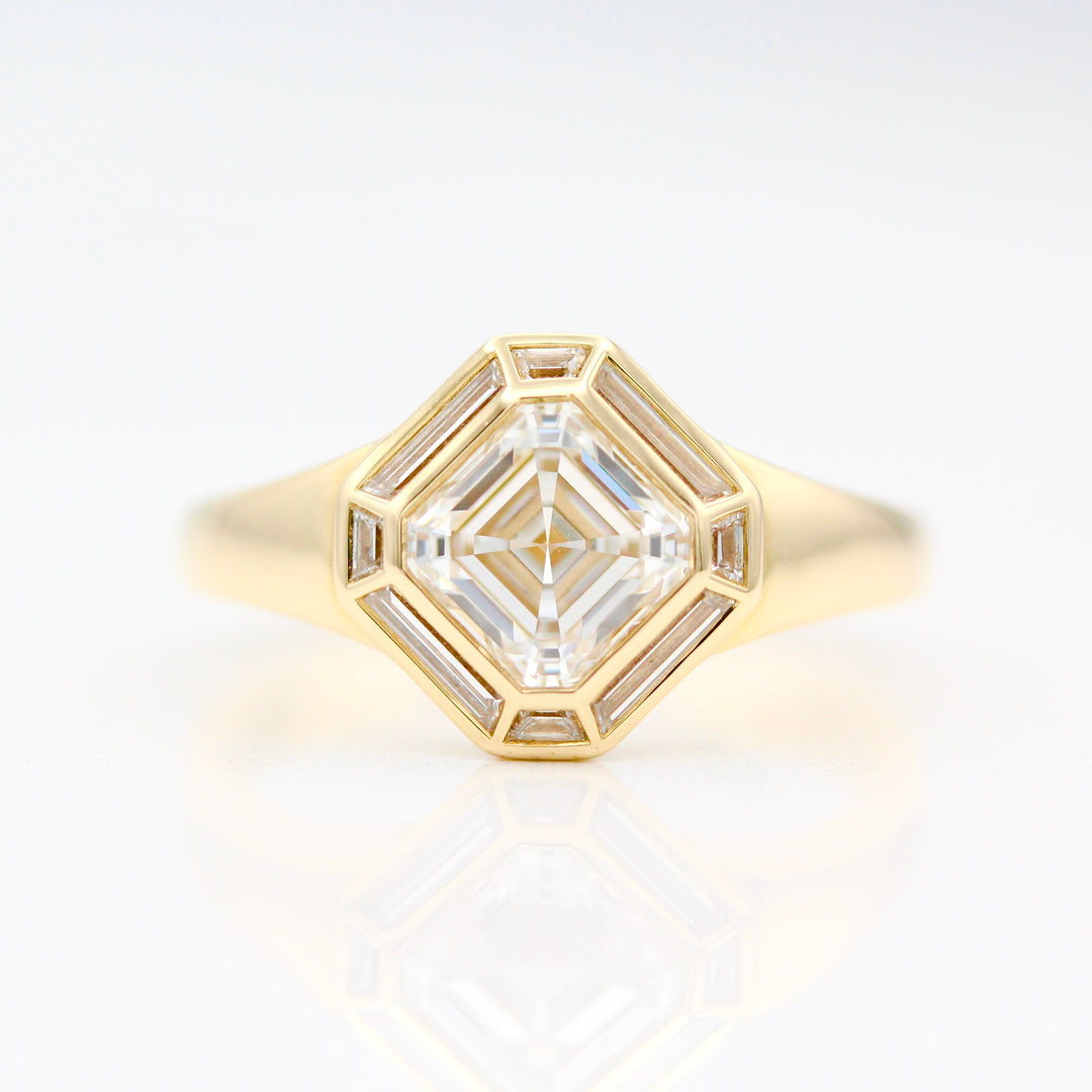 The Banks Engagement Ring in yellow gold with stunning asscher cut diamond center and elongated trapezoid accent stones on a white background
