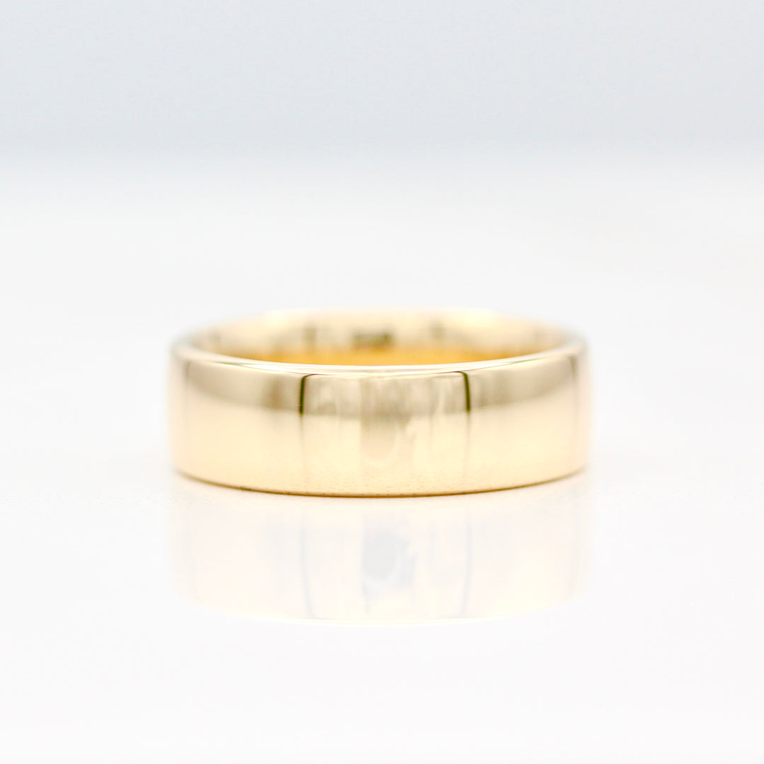 6.5mm Yellow gold plain sleek band on a white background