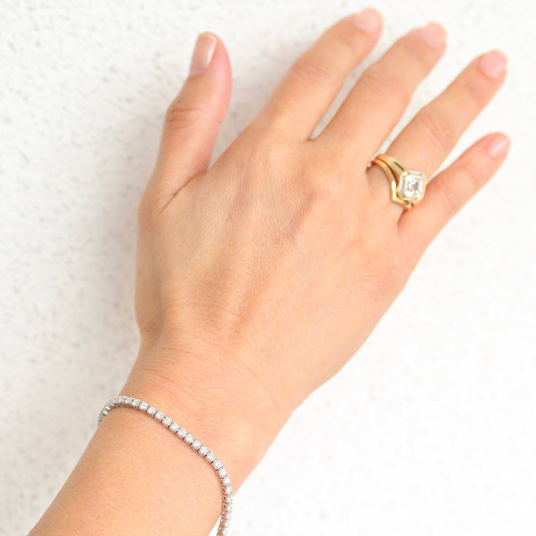 14k white gold diamond tennis bracelet on a glowy hand against a white background