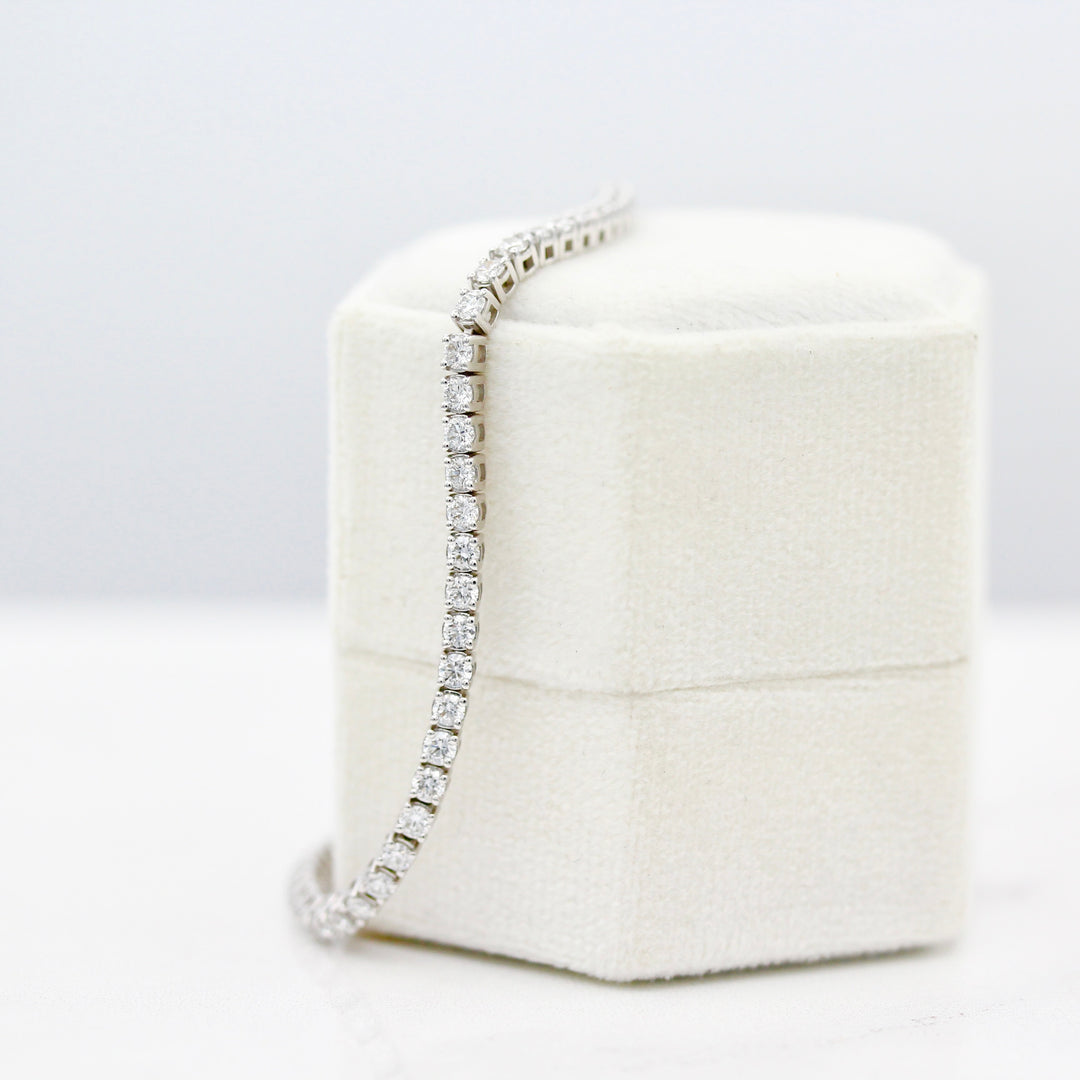 The Classic Lab-Grown Diamond Tennis Bracelet in White Gold draped on a white velvet ring box