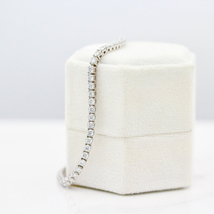 The Classic Lab-Grown Diamond Tennis Bracelet in White Gold draped on a white velvet ring box
