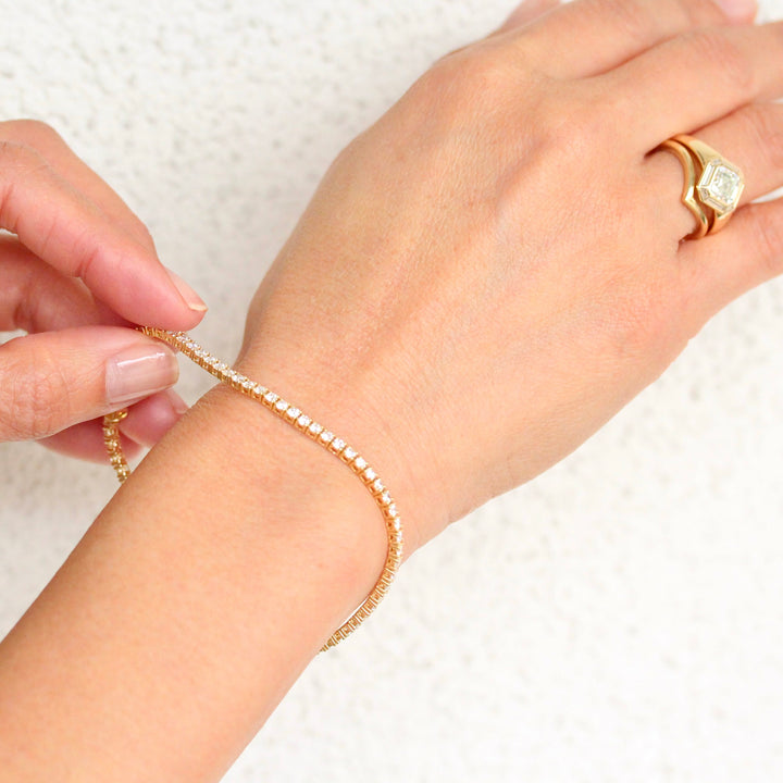 The Classic Lab-Grown Diamond Tennis Bracelet in Yellow Gold shown on a glowy hand