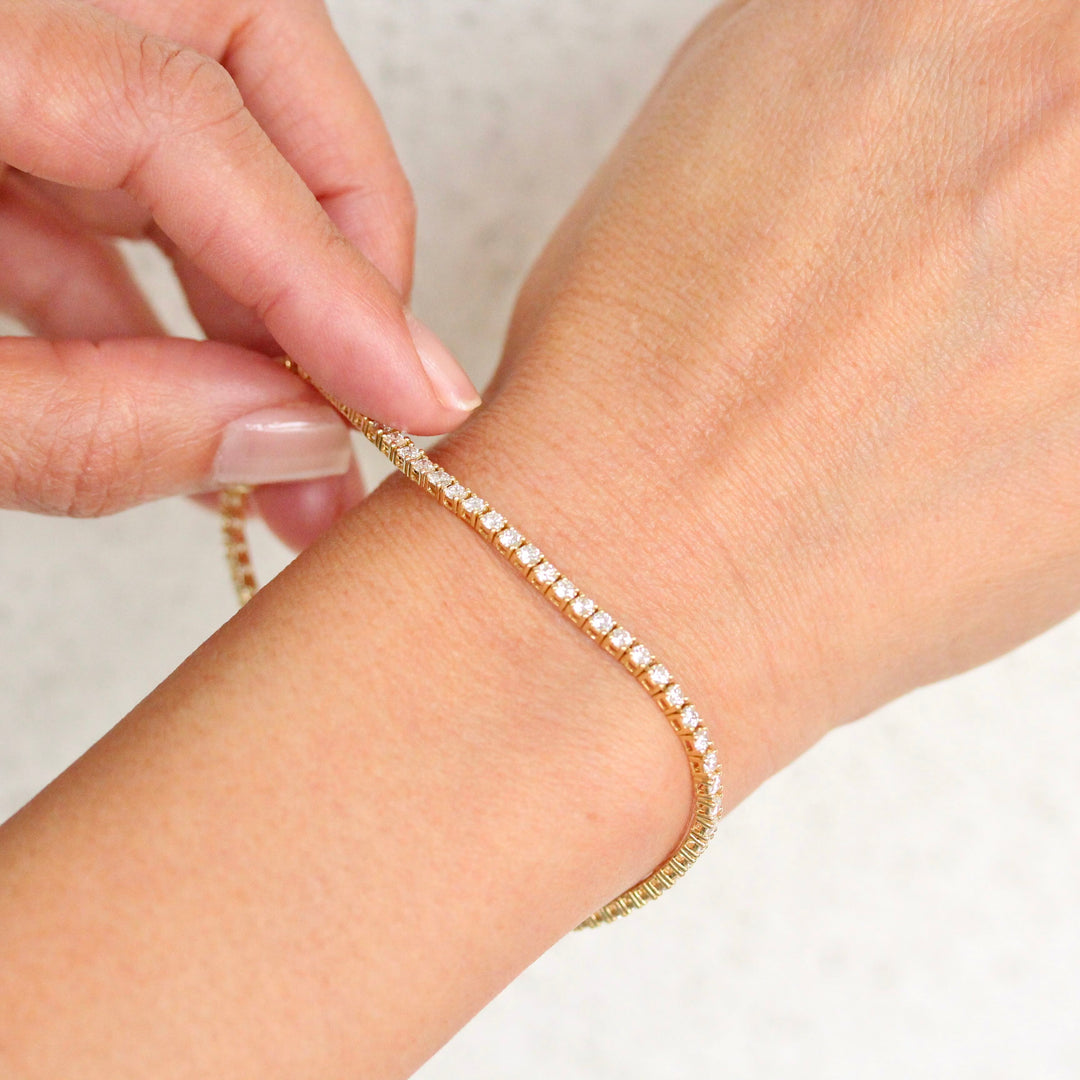 Yellow gold round diamond tennis bracelet on a hand
