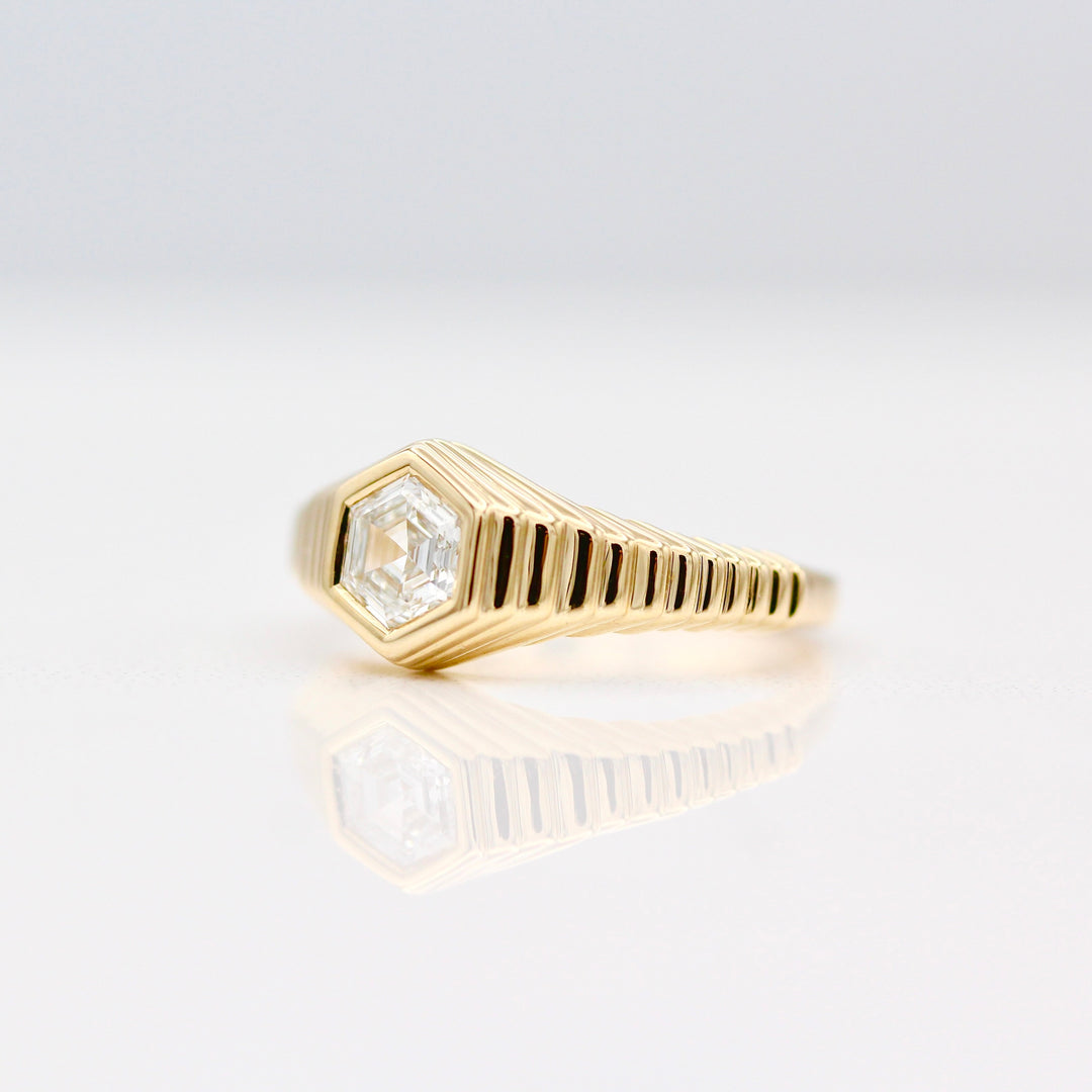 An angled view of The Fitz Pinky Ring in Yellow Gold on a White background