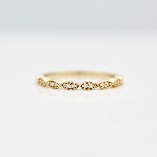 Twisty milgrain wedding band with round diamonds in yellow gold on a white background