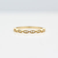 Twisty milgrain wedding band with round diamonds in yellow gold on a white background