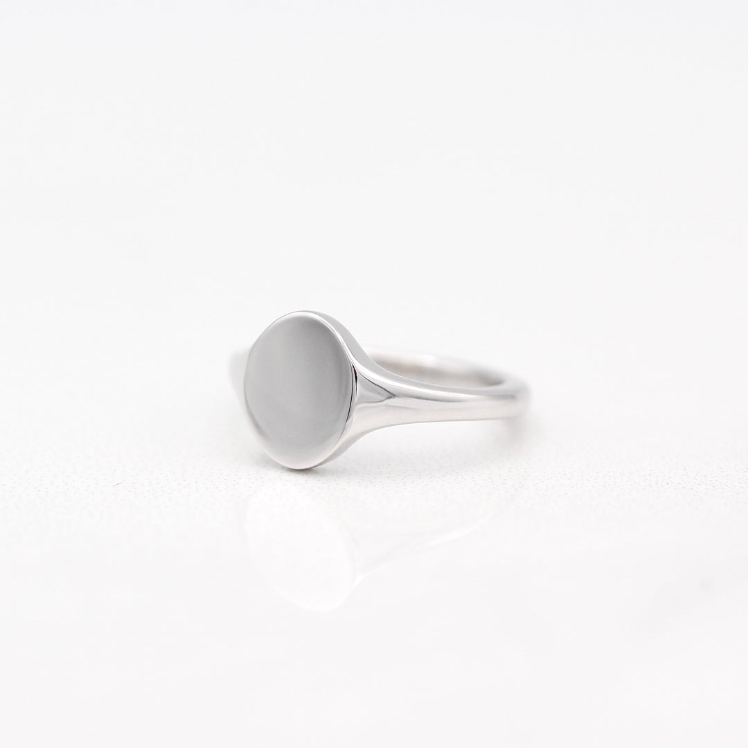 An angled view of an Oval Signet Pinky 
Ring in Sterling Silver on a White Background