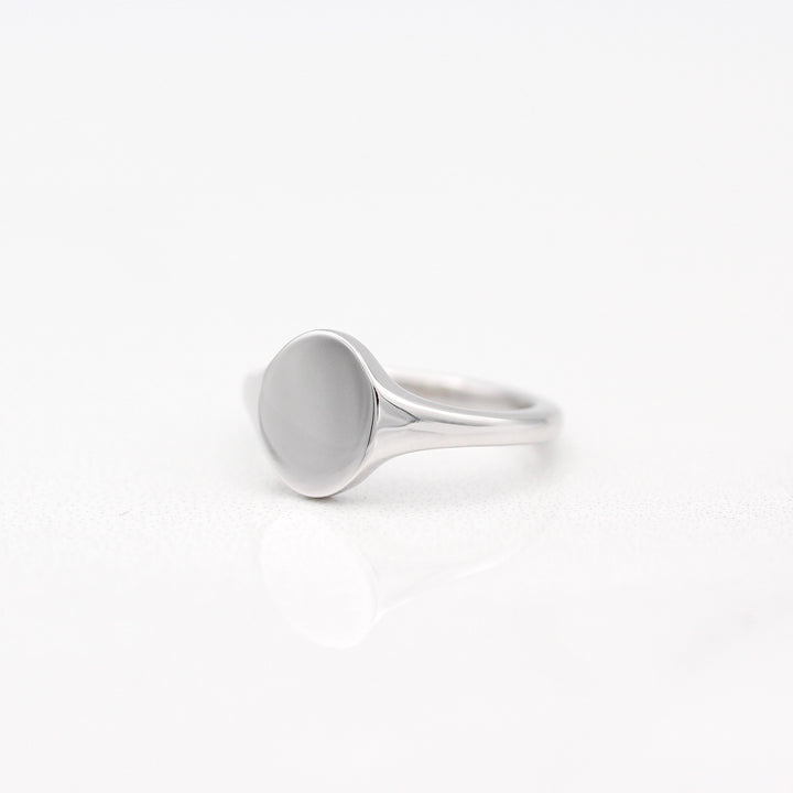 An angled view of an Oval Signet Pinky 
Ring in Sterling Silver on a White Background