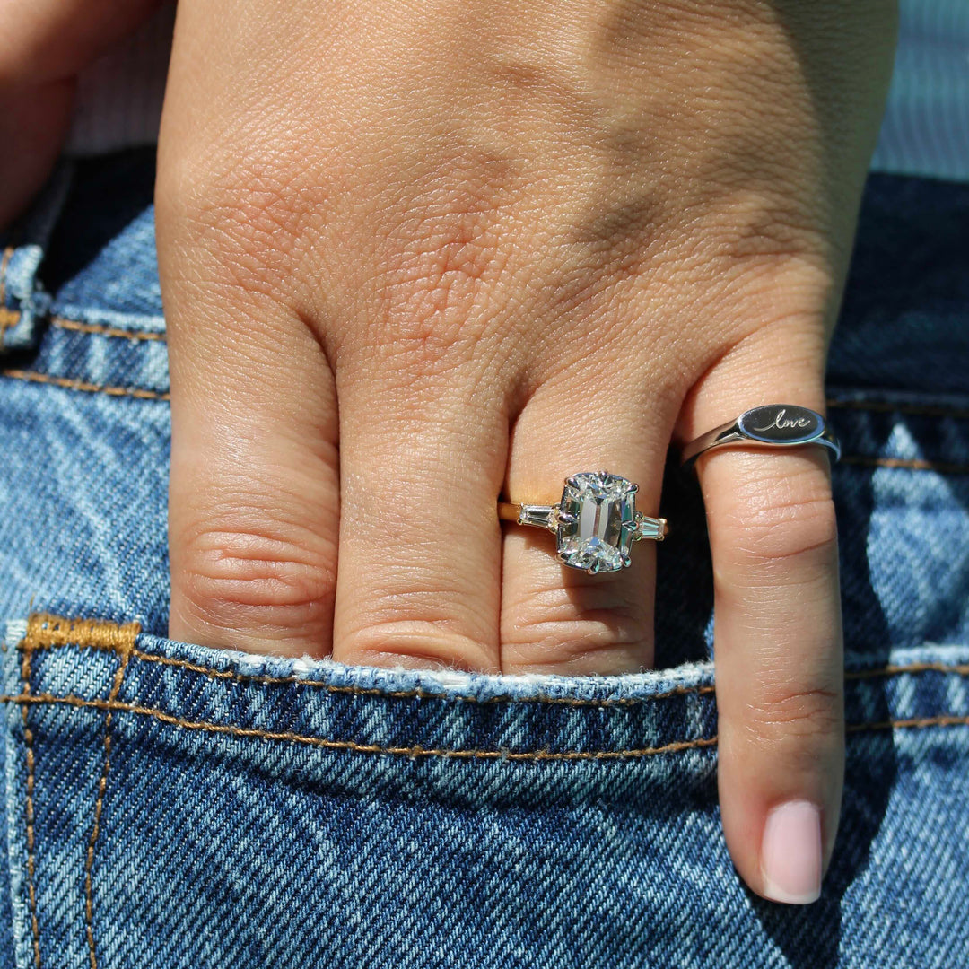 The sterling silver love pinky ring on a hand pair with the Vera engagement ring