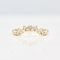 Curved yellow gold wedding band with 15 round diamond accents on a white background