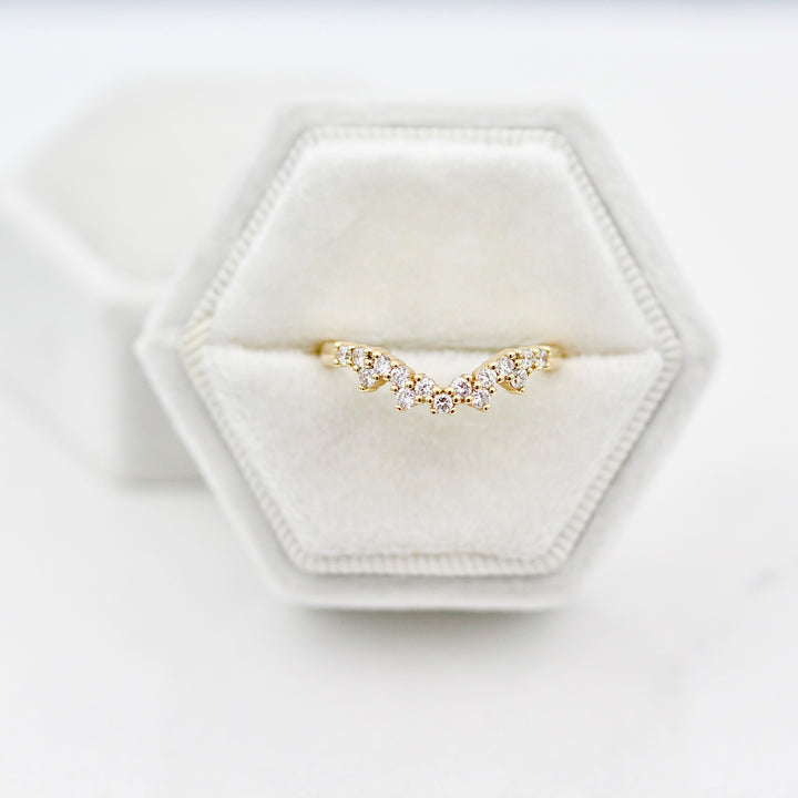 The Nova wedding band in yellow gold with round diamonds displayed in a white velvet ring box against a neutral background