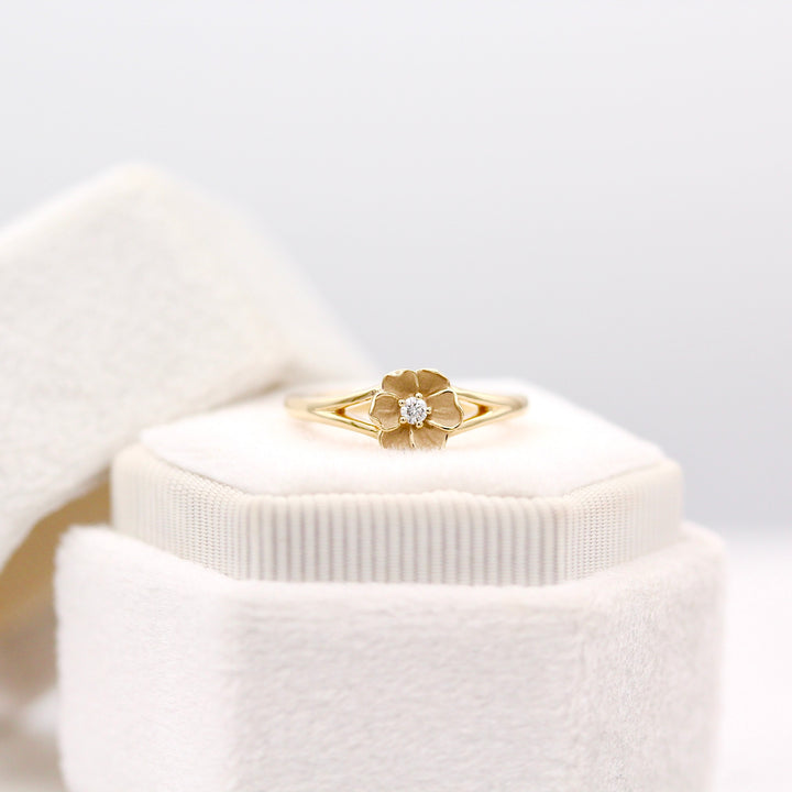 The Poppy Pinky Ring resting on a White Velvet Ring box with Round Lab Diamond center 