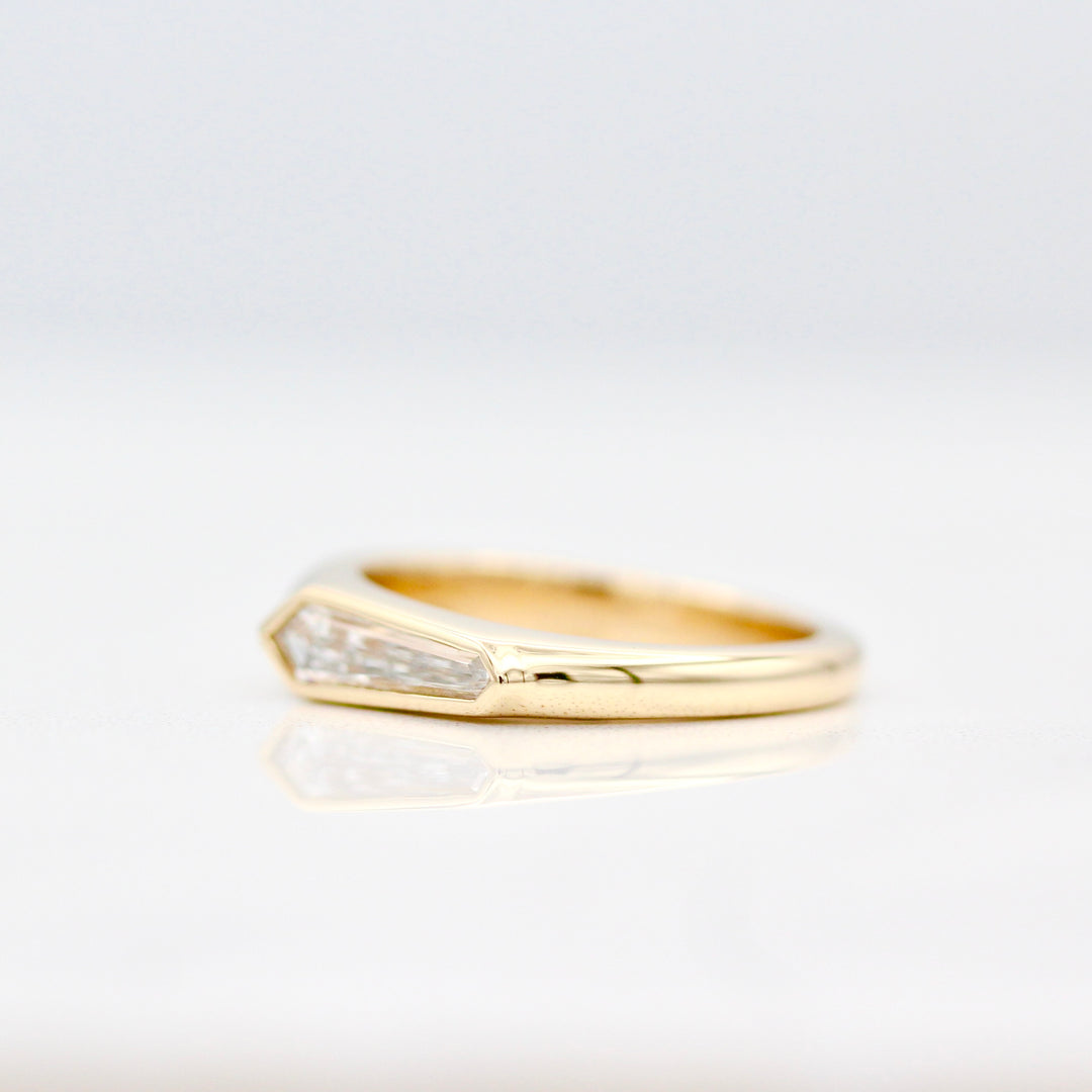 Angled view of the tapered band in yellow gold on a white background
