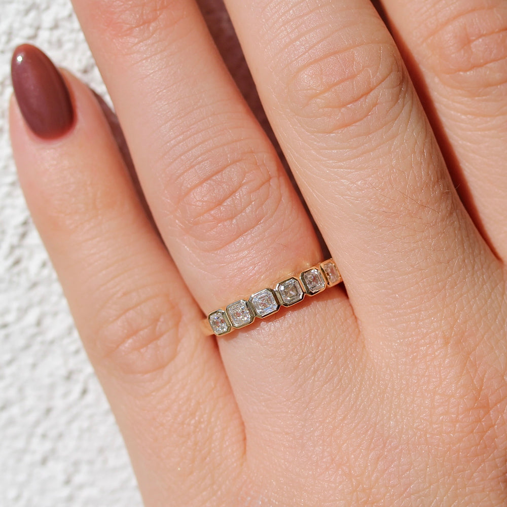 Close up of the Bezel set Asscher cut Diamond Ring in Yellow Gold on a Hand.