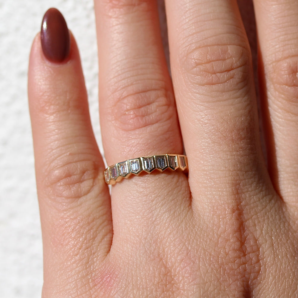 The Sammy Bullet Yellow Gold Wedding Band on a Hand with Neutral Background.