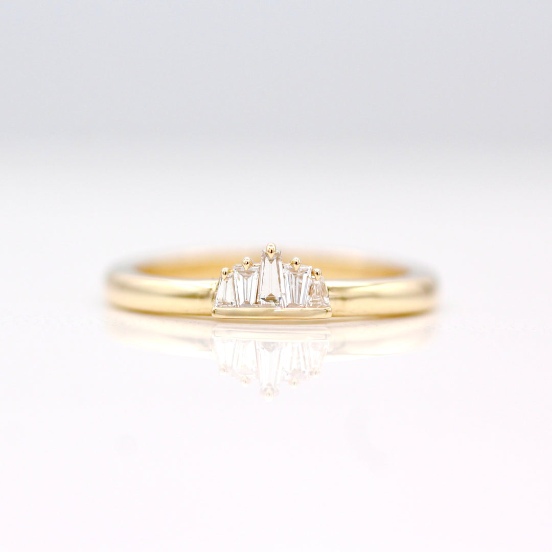 The True North Pinky Ring in Yellow Gold with 5 alternating tapered diamond baguettes on a neutral background